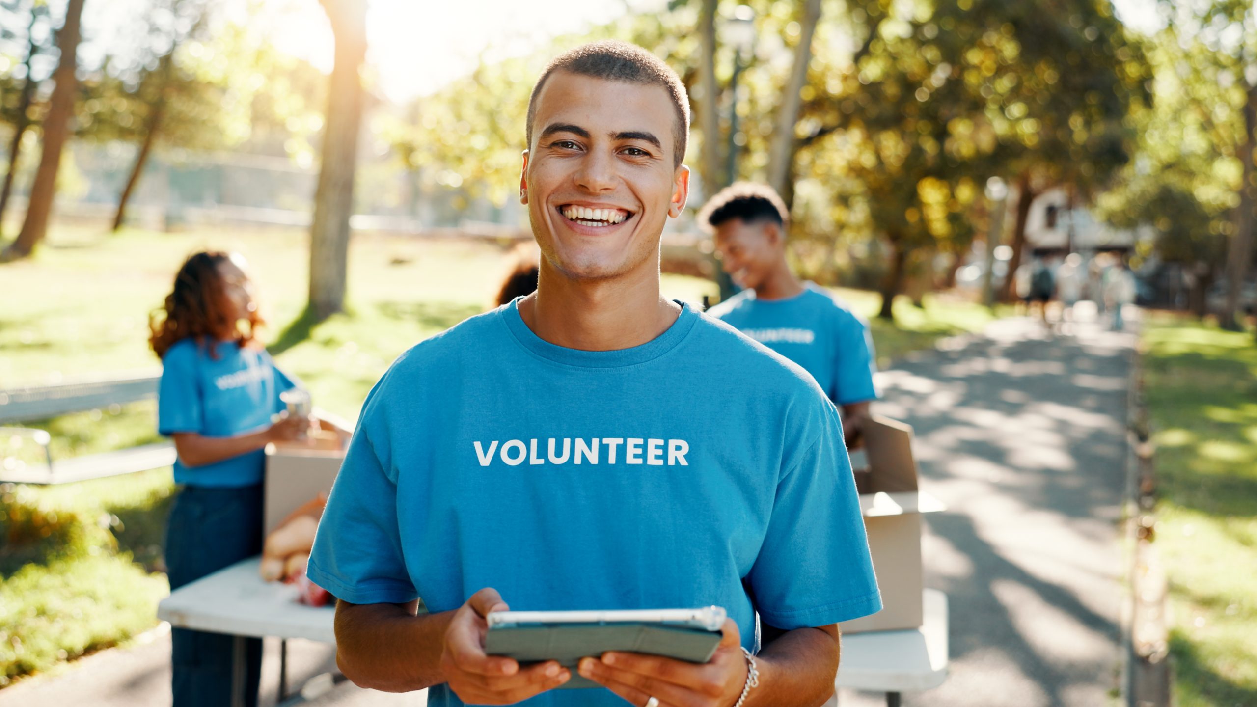 Outdoor portrait of a volunteer with a tablet using broadband for community support
